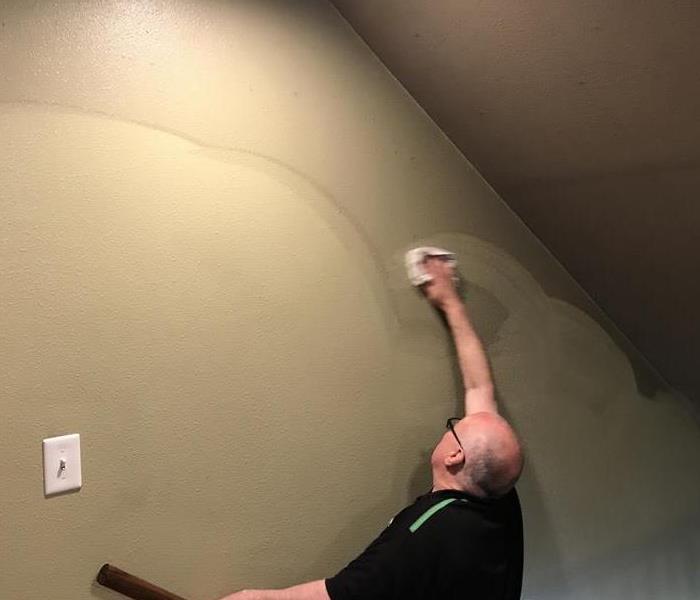 Our expert cleaning team hand wiping soot off stairwell walls